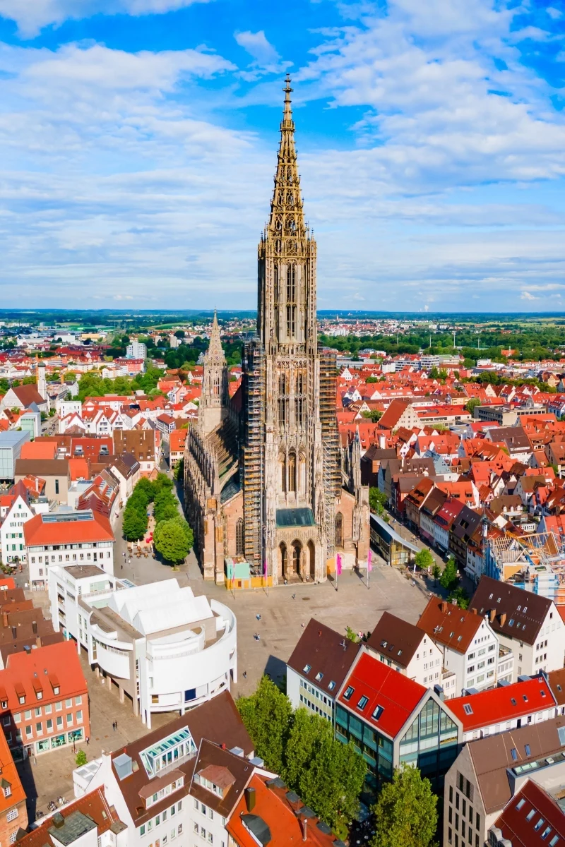 Katedra w Ulm. Przez 135 lat nikt nie potrafił zbudować wyższego kościoła Gotycka katedra z wysoką, strzelistą wieżą dominuje nad otaczającą ją zabudową miejską z czerwonymi dachami.
