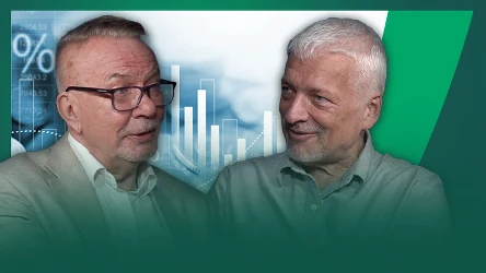 Dwóch starszych mężczyzn w okularach i jasnych koszulach rozmawia, w tle widoczne wykresy słupkowe i symbole procentowe nawiązujące do finansów lub ekonomii.