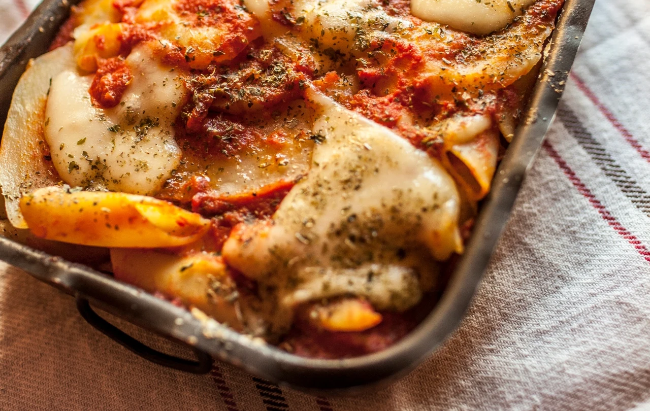 Pasta e patate alla tiella Zapiekanka pasta e patate alla tiella z makaronem penne, sosem pomidorowym, serem i ziołami w naczyniu żaroodpornym.