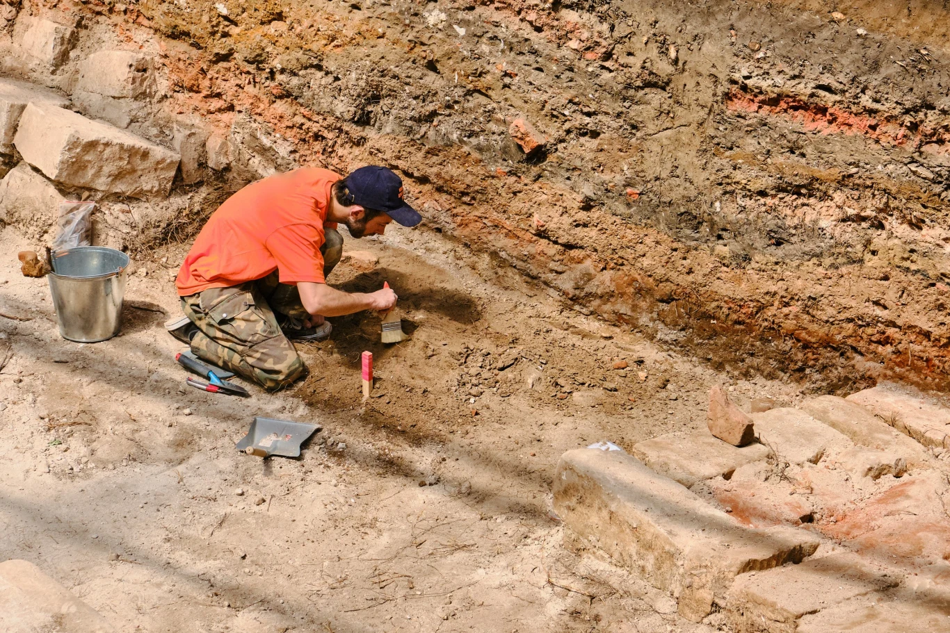 W hrabstwie Devon w Anglii odsłonięto bogatą rzymską willę z łaźnią. W jednym z pomieszczeń znajdowała się misterna mozaika. Archeolog klęcząc odsłania pędzlem mozaikę w wykopie na terenie ruin rzymskiej willi odkrytej w Devon w Anglii.