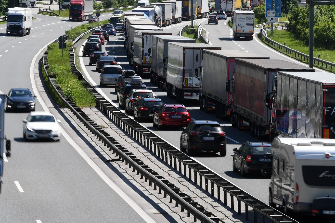 W wybranych obszarach w Austrii i Niemczech omijanie korków na autostradach lokalnymi drogami jest zabronione. Samochody osobowe i ciężarówki stoją w długim korku na autostradzie, drugi pas ruchu wolny.