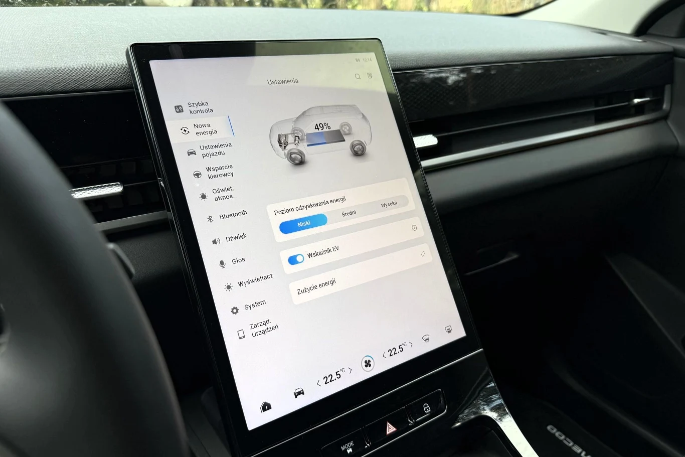 Niemal wszystkimi funkcjami Jaecoo 5 Hybrid (podobnie jak w innych odmianach napędowych) sterujemy z poziomu 13,2-calowego wyświetlacza. Panel centralny samochodu elektrycznego z dużym, pionowym ekranem dotykowym wyświetlającym informacje o stanie naładowania baterii oraz opcjach zarządzania energią.