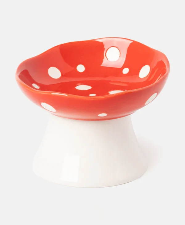 Ceramiczna miska o kształcie muchomora z wypukłym, czerwonym kapeluszem w białe kropki oraz szeroką, białą podstawą.