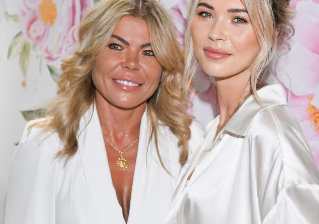 Grace Kubicka i Sandra Kubicka Grace Kubicka i Sandra Kubicka na jednym zdjęciu. Matka i córka ubrane w podobne, białe stylizacje, na tle kwiatowej ścianki.