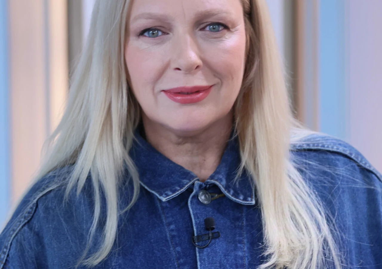 Katarzyna Nosowska Katarzyna Nosowska w niebieskiej dżinsowej koszuli z mikrofonem przy kołnierzu.