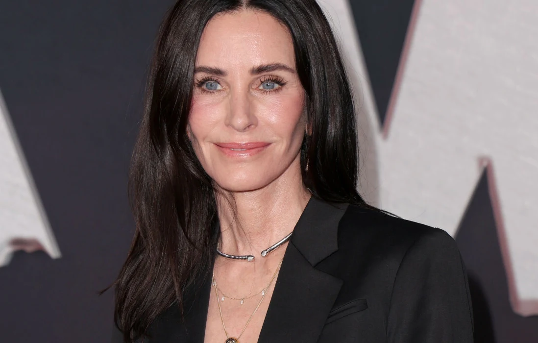 Courteney Cox Aktorka Courteney Cox pozująca w czarnej marynarce. Ma długie, ciemne włosy i niebieskie oczy.