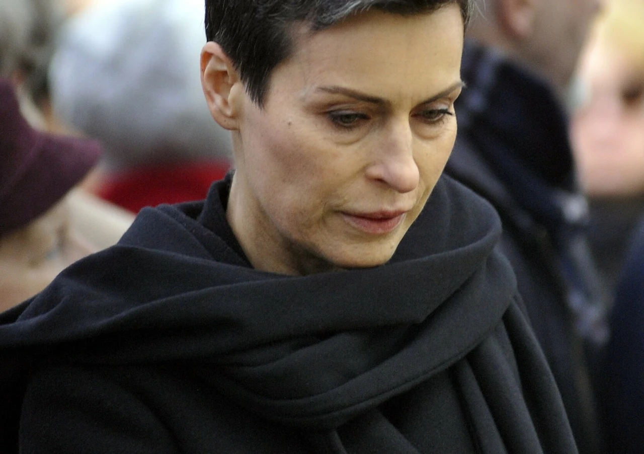 Danuta Stenka Danuta Stenka w czarnym ubraniu, z krótkimi, ciemnymi włosami, patrząca w dół, na tle innych osób.