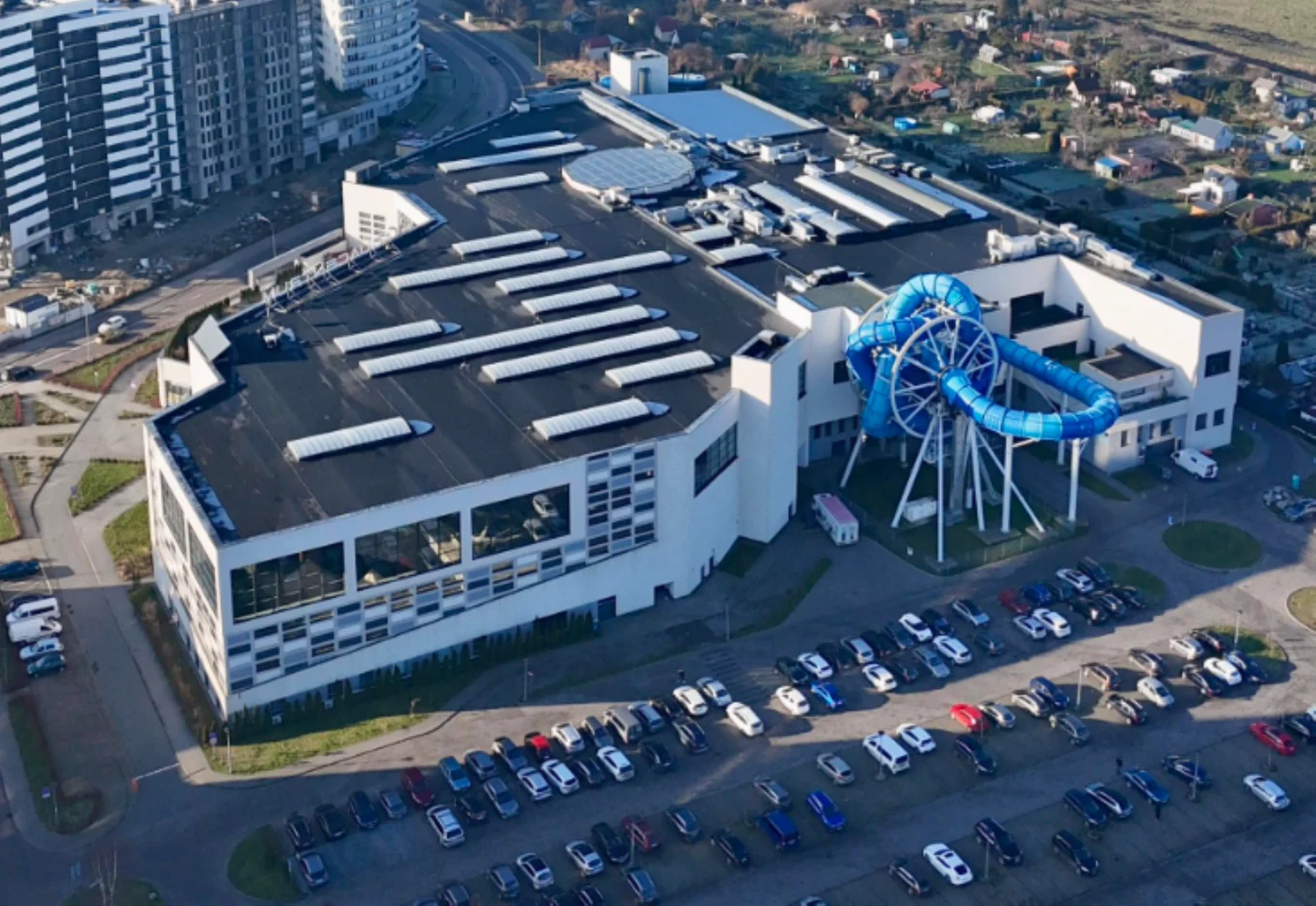 Wyciek substancji chemicznej w aquaparku w Redzie. Tragiczny finał Aquapark w Redzie z niebieską zjeżdżalnią wodną i parkingiem pełnym samochodów, widok z zewnątrz.