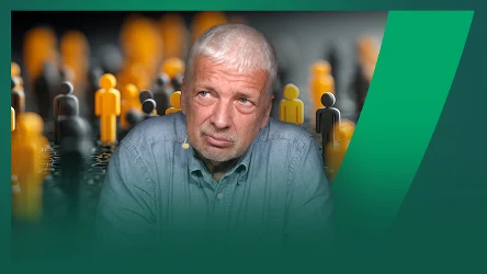 Starszy mężczyzna o siwych włosach z zamyśloną miną na tle licznych żółtych i czarnych figur przedstawiających ludzi, ustawionych w rzędach.