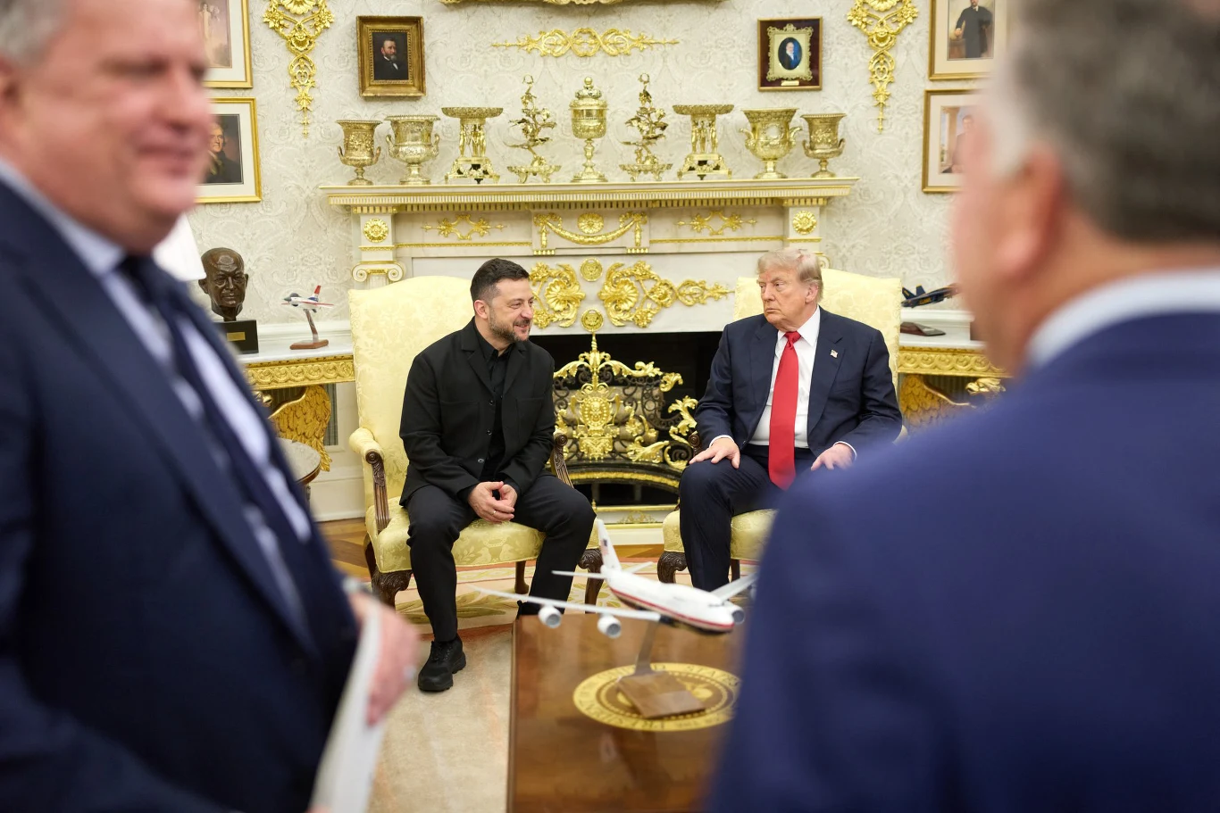 Zdjęcie ze spotkania Trumpa z Zełenskim Donald Trump i Wołodymyr Zełenski siedzą naprzeciw siebie w eleganckim gabinecie, na stole model samolotu.