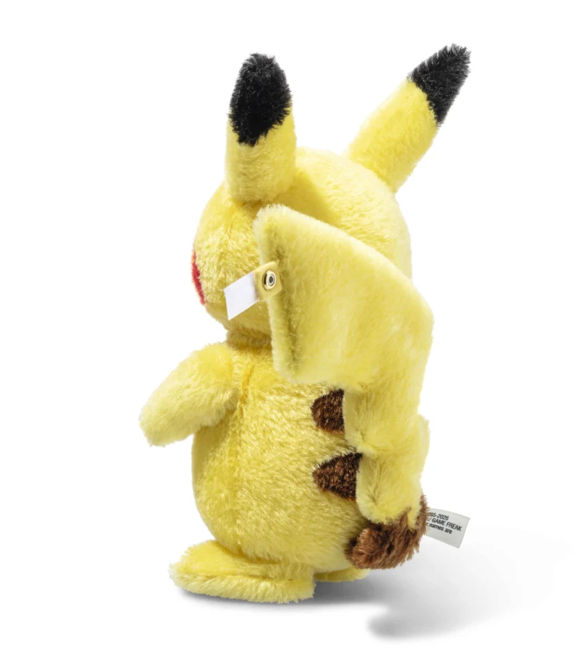 źródło: Steiff Pluszowa maskotka Pikachu z charakterystycznymi czarnymi końcówkami uszu, żółtym futerkiem i brązowym ogonem przypominającym błyskawicę.