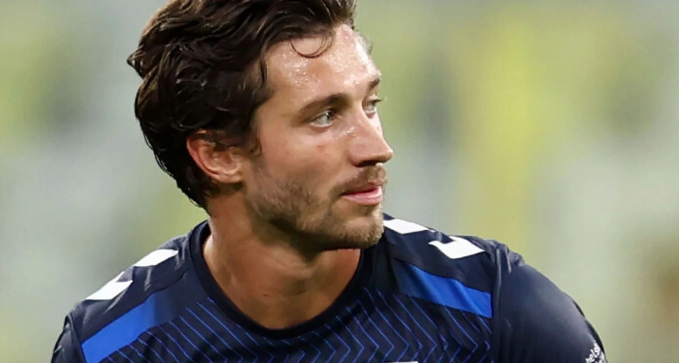 Hervé Matthys Mężczyzna w granatowej koszulce sportowej z krótkimi rękawami, patrzący w lewo podczas meczu lub treningu.