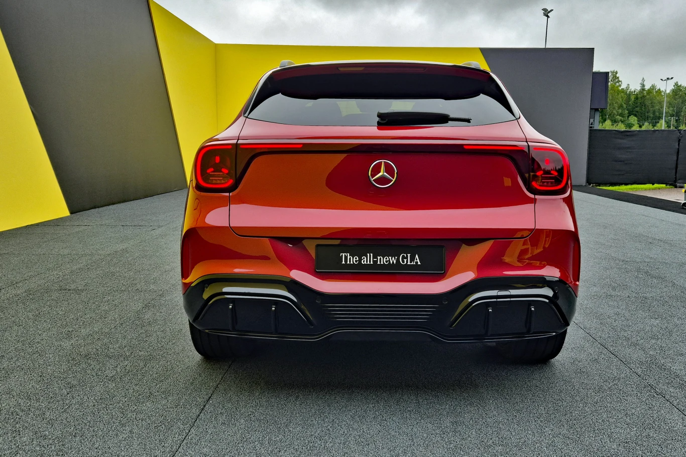 Czerwony Mercedes-Benz GLA widziany od tyłu, wyróżniający się dynamiczną linią, nowoczesnymi światłami tylnymi oraz sportowym dyfuzorem.