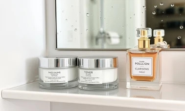 Kremy do twarzy, tonik i flakon perfum na półce łazienkowej — kosmetyki z oferty Hebe