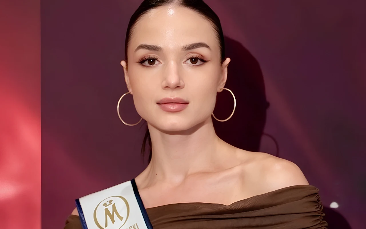 Młoda kobieta z gładko zaczesanymi włosami, w dużych złotych kolczykach i eleganckiej brązowej sukni.