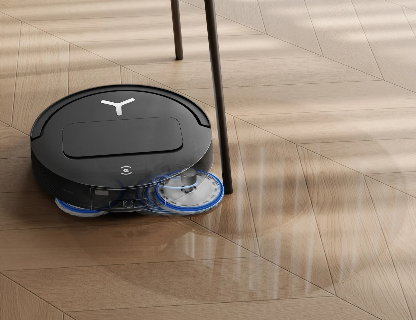 Sprzątanie z ECOVACS DEEBOT T50 OMNI Gen3 ogranicza się do wydania jednego polecenia w aplikacji Czarny robot sprzątający z okrągłymi szczotkami myjącymi porusza się po jasnej, drewnianej podłodze i omija nogę krzesła.