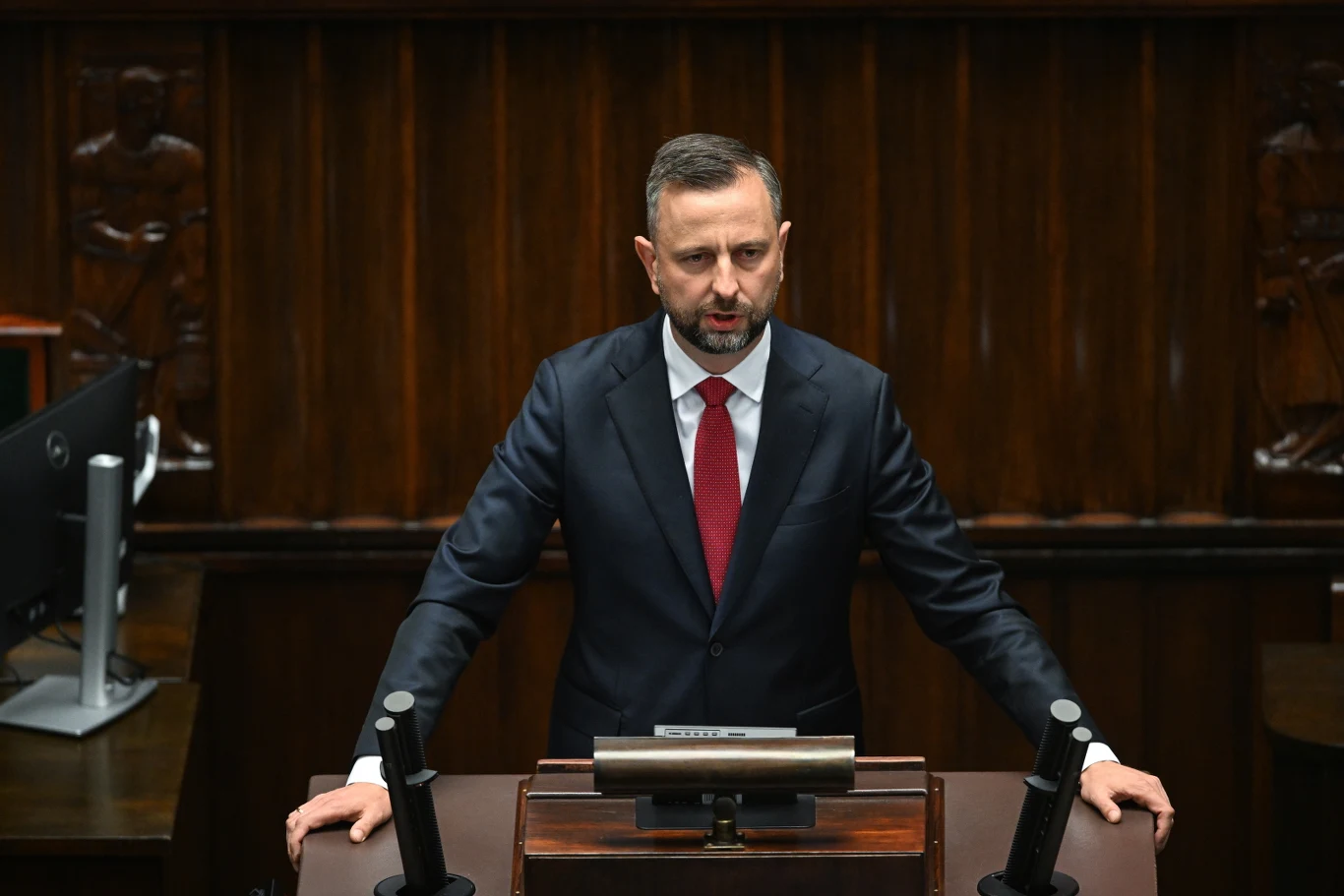 Według szefa MON analiza pocisku Ch-101, który spadł w Polsce świadczy, że Rosja wyczerpała zapasy wojenne Minister Władysław Kosiniak-Kamysz w garniturze przy mównicy sejmowej z czerwonym krawatem, ręce na pulpicie.