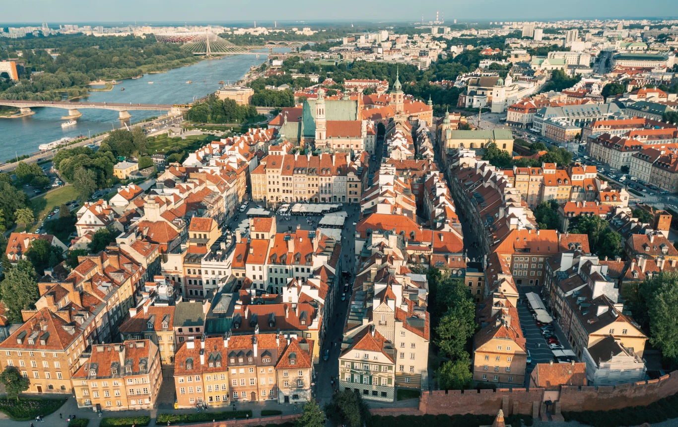 Niedaleko Warszawy znajduje się piaszczysta, spokojna plaża, gdzie amatorzy zieleni mogą swobodnie wypocząć. To świetny pomysł na choćby jednodniowy wyjazd. Dokąd się udać? Stare Miasto w Warszawie z charakterystyczną zabudową, Zamkiem Królewskim w centrum i widoczną w tle rzeką Wisłą.