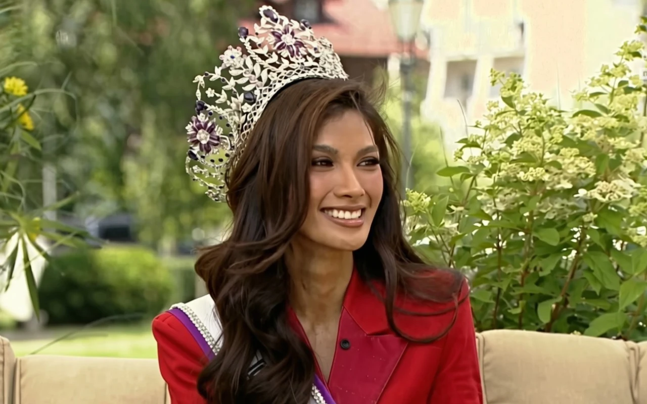 Nowa Miss Supranational zakochała się w Polsce. "Czuję się jak w domu" Katrina Llegado w czerwonej marynarce, z koroną i szarfą, siedzi na kremowej sofie w otoczeniu zieleni.