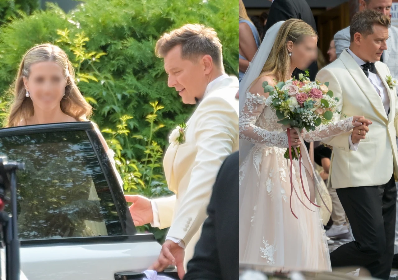 Para młoda ubrana w eleganckie stroje ślubne, panna młoda w białej sukni z koronkami oraz bukietem kwiatów, pan młody w białej marynarce, wspólnie wychodzą przed budynek i wsiadają do samochodu.