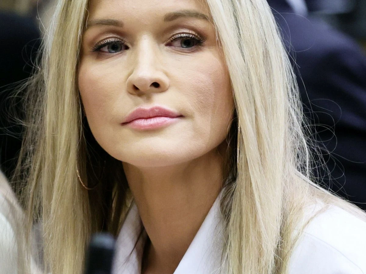 Joanna Krupa Joanna Krupa w białej koszuli i z długimi blond włosami, patrząca w bok.
