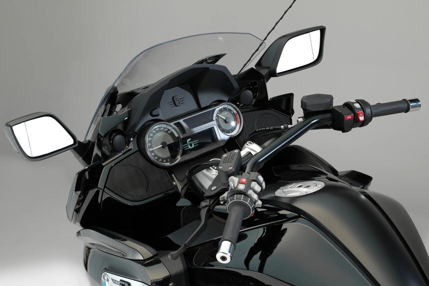Radio jest nieodłącznym elementem motocykli turystycznych. Kokpit motocykla z widocznymi zegarami, kierownicą oraz lusterkami, wykończony w czarnym połysku.