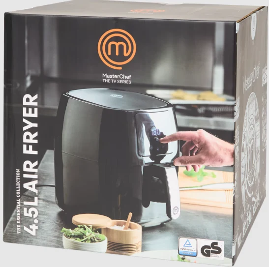 Czarna frytkownica beztłuszczowa z dotykowym panelem sterowania, użytkowana przez rękę, pudełko opatrzone logo MasterChef oraz napisem 4.5 L AIR FRYER, w tle minimalistyczny blat kuchenny z pojemnikami na zioła.