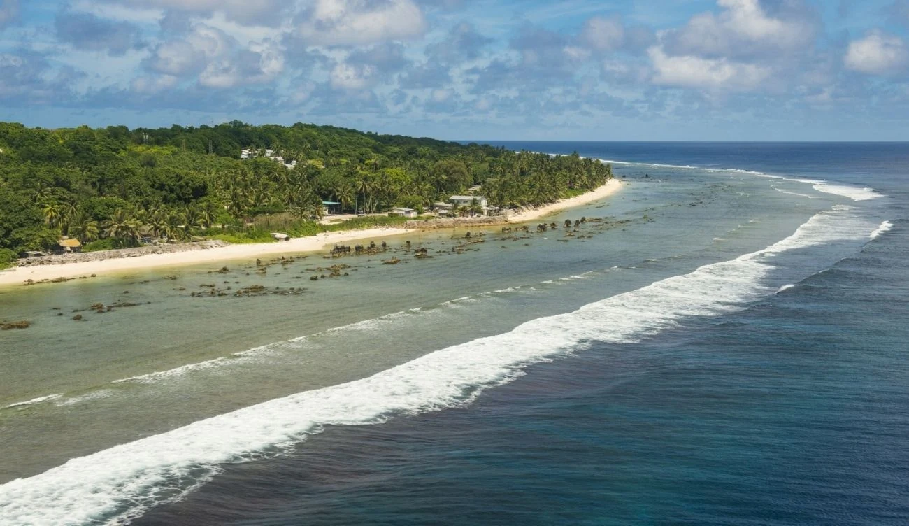 Nauru oficjalnie zmienia nazwę na Republikę Naoero Plaża Nauru z tropikalną roślinnością, ocean i turkusowa woda, kraj zmienia nazwę na Republikę Naoero.