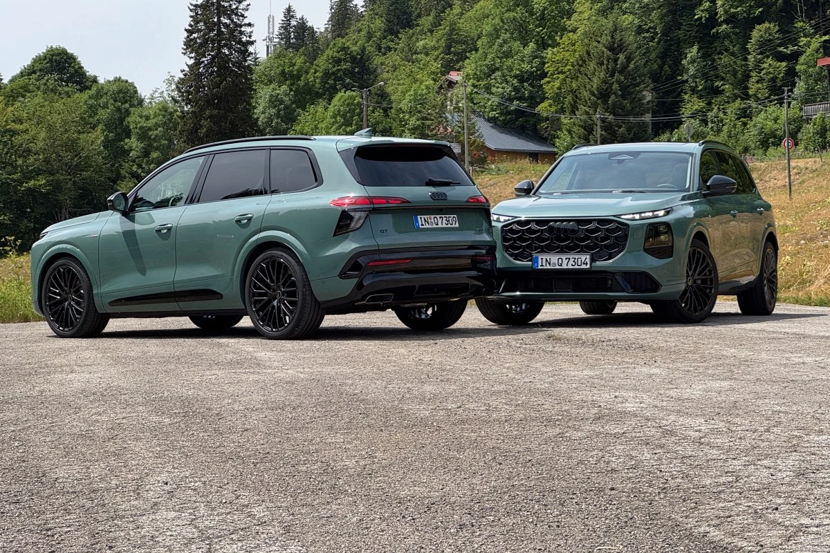 Dwa zielone SUV-y nowoczesnego designu zaparkowane na otwartej przestrzeni w otoczeniu zielonych drzew i pagórków.