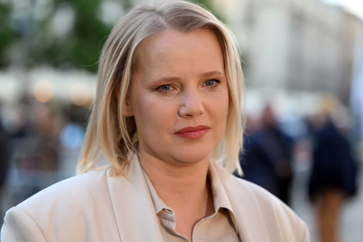 Joanna Kulig Joanna Kulig w kremowej marynarce, jasne włosy, niebieskie oczy, na zewnątrz podczas wydarzenia miejskiego.