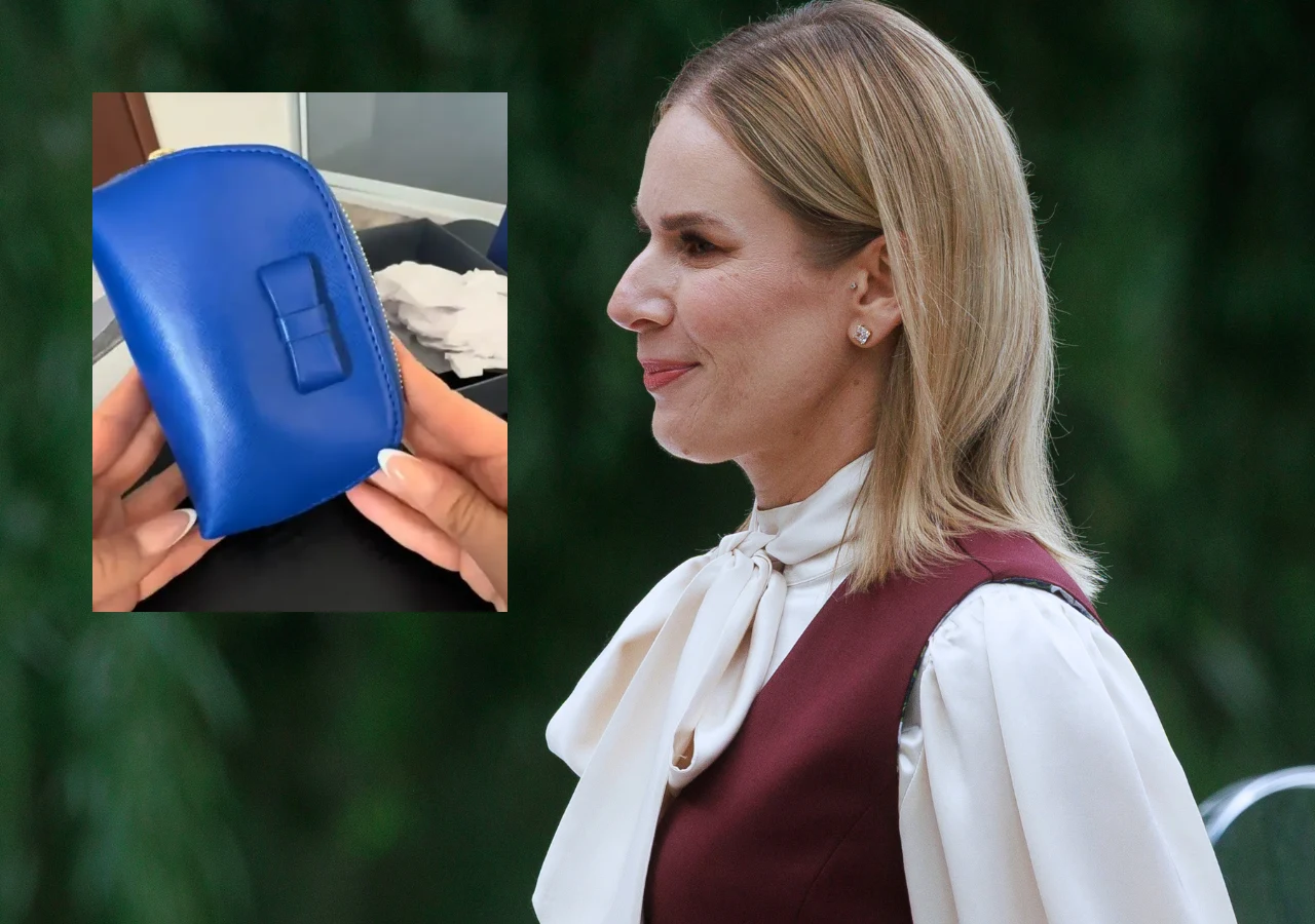 Anna Misztela pokazuje prezent od Marty Nawrockiej Kobieta w eleganckiej stylizacji, bordowej sukience bez rękawów na białej bluzce z wiązaniem pod szyją, obok zbliżenie na niebieski portfel trzymany w dłoniach.