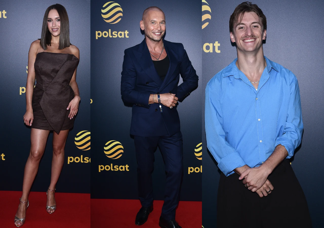 Trzy osoby pozujące na tle ścianki z logo Polsat – kobieta w eleganckiej, brązowej sukience, mężczyzna w granatowym garniturze oraz mężczyzna w jasnoniebieskiej koszuli, wszyscy uśmiechnięci, w stylizacjach wieczorowych.