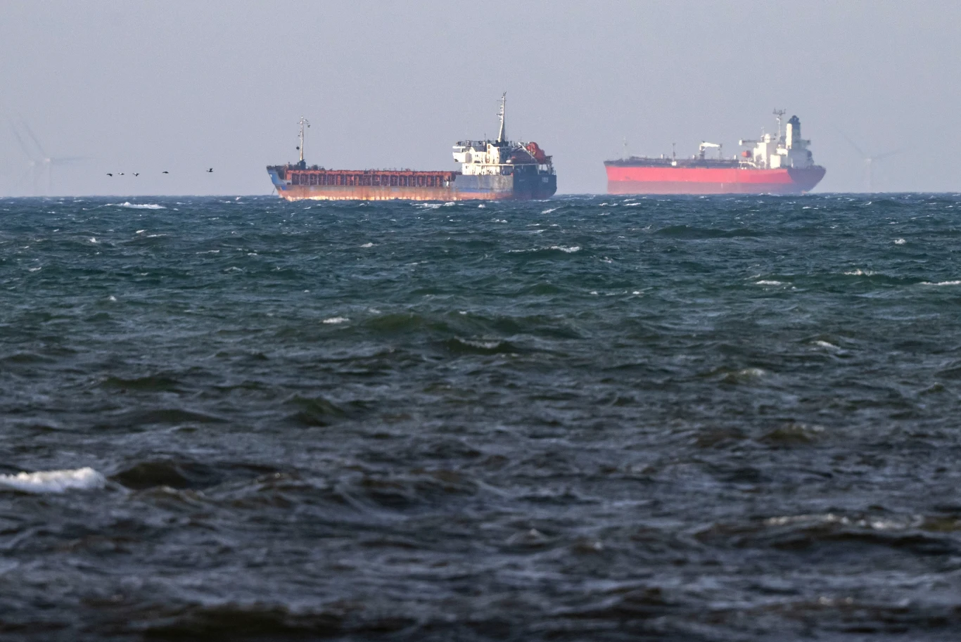 Jednostki "Caffa" (po lewej) i "Sea Owl I" na morzu Statki towarowe Caffa i Sea Owl I płyną na wzburzonym morzu, zamglone niebo w tle.