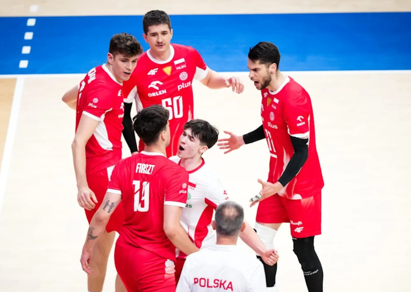 Bartosz Gomułka (u góry zdjęcia) podpisał nowy, długi kontrakt Bartosz Gomułka na górze. Siatkarze Polski w czerwonych i białych strojach podczas rozmowy na boisku.