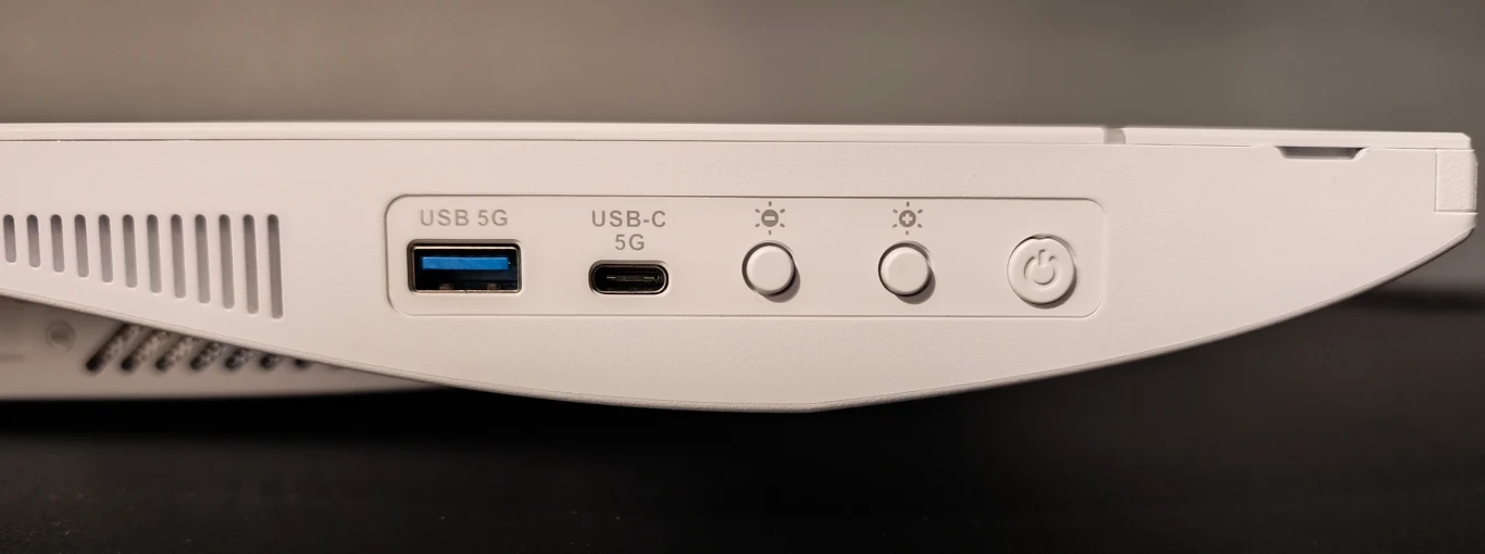 MSI PRO MAX 27P Z Port USB, port USB-C, dwa przyciski regulujące jasność oraz przycisk zasilania na bocznym panelu białego urządzenia elektronicznego.