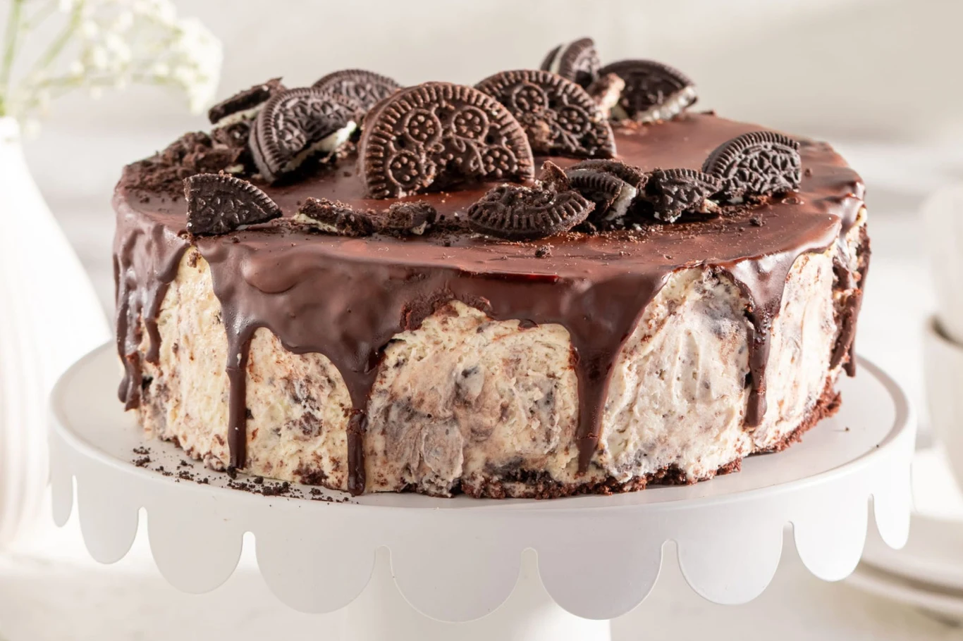 Imponujący tort Oreo możesz zrobić samemu w domu Tort Oreo z warstwą kremu, oblaną polewą czekoladową i udekorowany kawałkami ciasteczek Oreo na wierzchu.