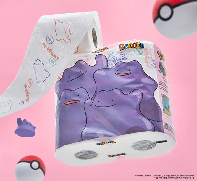 Rolka papieru toaletowego z wizerunkiem postaci Ditto z Pokémonów na opakowaniu i nadrukami Ditto na samym papierze, otoczona kilkoma pokeballami na różowym tle.