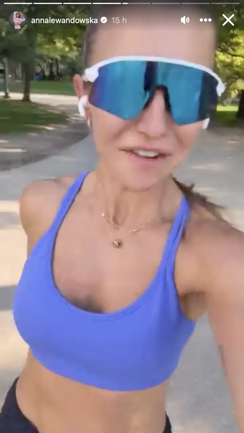 Anna Lewandowska została rozpoznana na ulicach Chicago Kobieta w sportowym stroju biegnąca po parkowej alejce, w dużych okularach przeciwsłonecznych i słuchawkach bezprzewodowych, otoczona zielenią drzew.