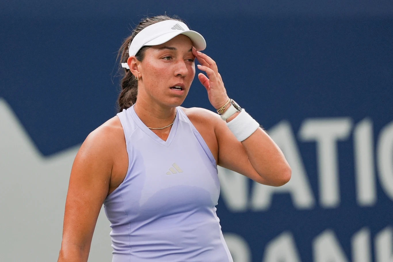 Jessica Pegula Tenisistka w sportowym stroju i opasce na głowie ociera czoło dłonią, wyrażając zmęczenie podczas meczu na korcie tenisowym.