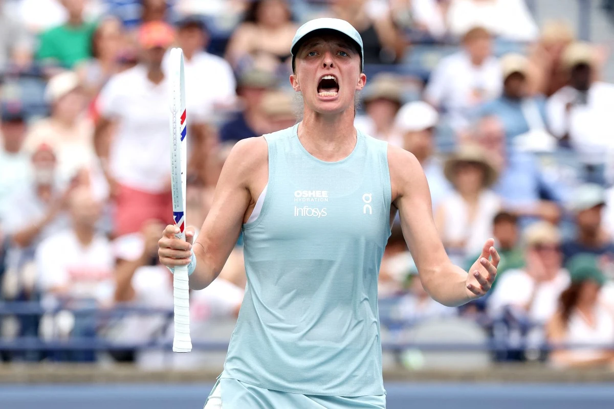 Iga Świątek awansowała do ćwierćfinału WTA 1000 w Toronto Tenisistka w jasnoniebieskim stroju i czapce z daszkiem trzyma rakietę i wyraża silne emocje, gestykulując rękami na korcie podczas meczu.
