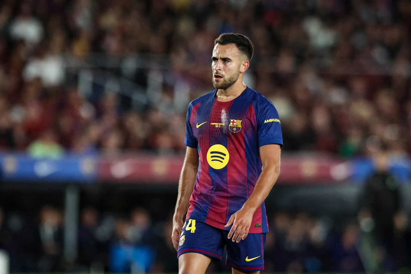 Piłkarz w koszulce FC Barcelony idący po murawie boiska podczas meczu, skoncentrowany i gotowy do dalszej gry.