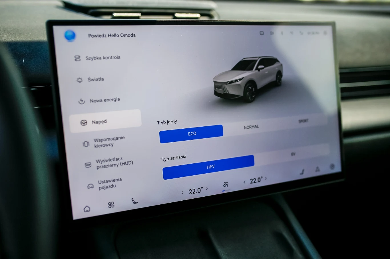 Omoda 7 Super Hybrid nawet w trybie Eco jest chętna do jazdy, zaś po wybraniu Sport robi się wyrywna Dotykowy ekran systemu multimedialnego samochodu z wizualizacją pojazdu, ustawieniami trybu jazdy i klimatyzacji.