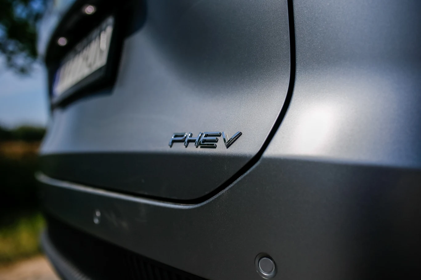Omoda 7 Super Hybrid Detaliczny widok tylnej części samochodu z emblematem PHEV umieszczonym na karoserii.