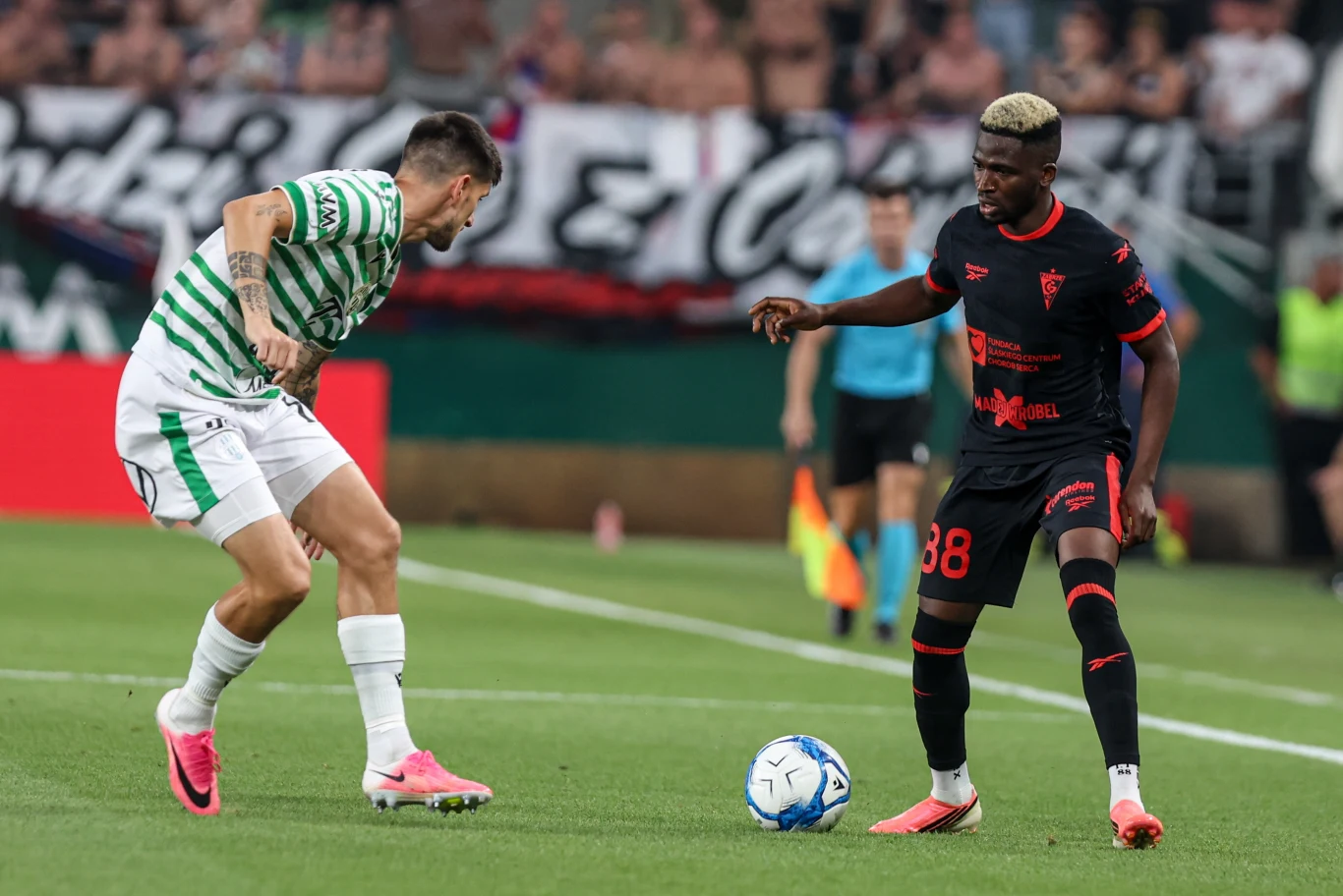 Taofeek Ismaheel w barwach Górnika Zabrze podczas meczu z Ferencvarosem Taofeek Ismaheel z Górnika Zabrze z piłką, obok zawodnik Ferencvarosu w trakcie meczu eliminacji Ligi Europy.