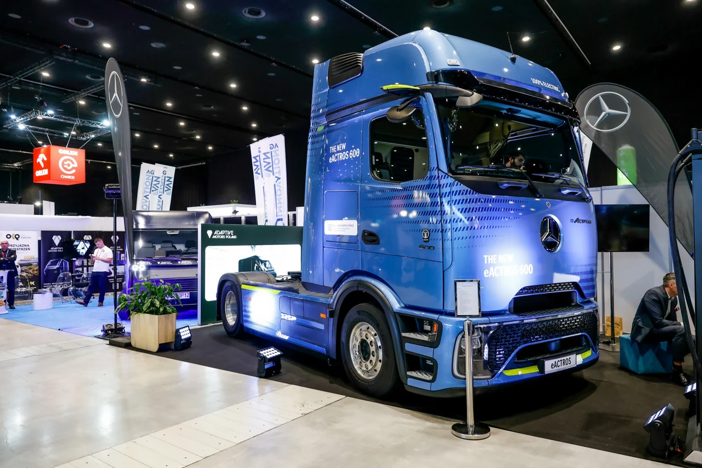 Daimler Truck może zapłacić 1 mld euro. Powodem są elektryki. Mercedes eActros w niebieskim kolorze na stoisku targowym Daimler Truck, otoczony firmowymi banerami