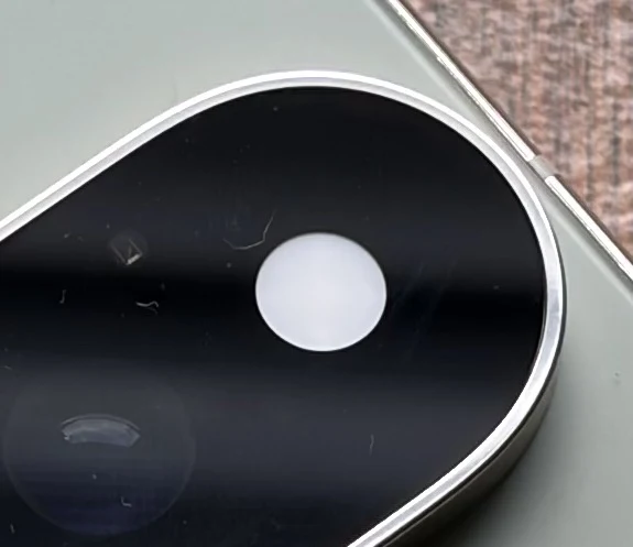 Funkcja HiLight z Google Pixel 11 Pro działa w oparciu o spechalną diodę LED. Obiektyw aparatu smartfona z wyraźnie widoczną soczewką oraz srebrna ramka wokół modułu aparatu na tle obudowy urządzenia.
