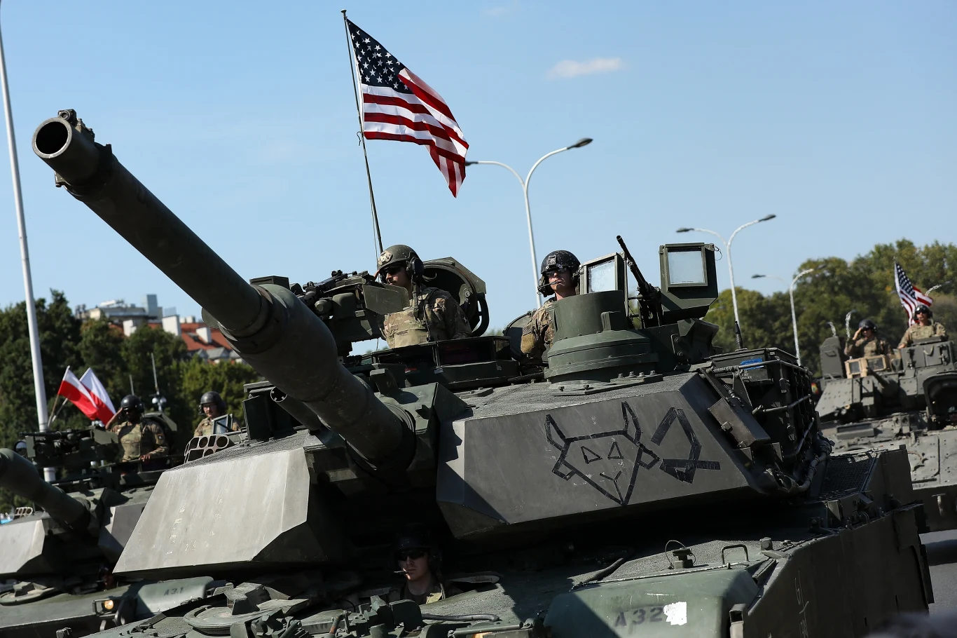 Amerykanie: "To nie tylko parada. To widoczny dowód, że jesteśmy tu razem" Czołg z amerykańską załogą, oznaczenia militarnie namalowane na pancerzu, flaga Stanów Zjednoczonych powiewająca nad pojazdem.