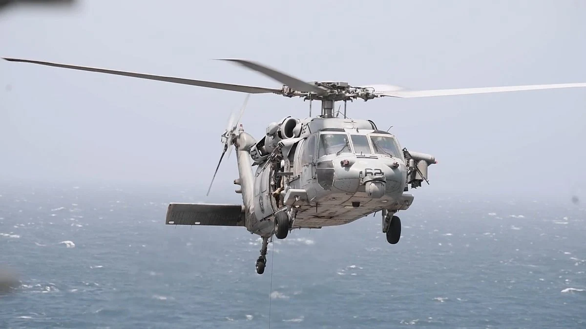 Amerykański śmigłowiec MH-60 Amerykański śmigłowiec wojskowy MH-60 w locie nad otwartym morzem, stalowoszary kadłub, wirniki w ruchu.