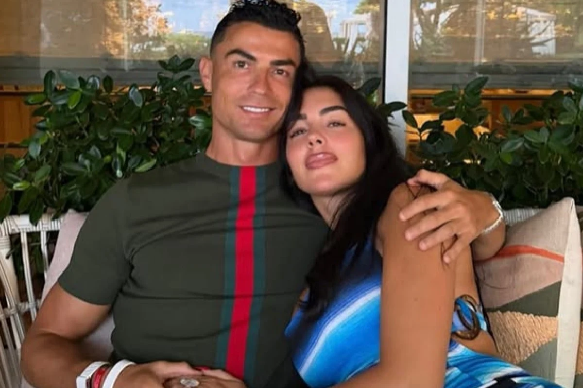 Georgina Rodriguez, Cristiano Ronaldo Georgina Rodriguez i Cristiano Ronaldo siedzą razem, obejmując się, w tle zielone rośliny.