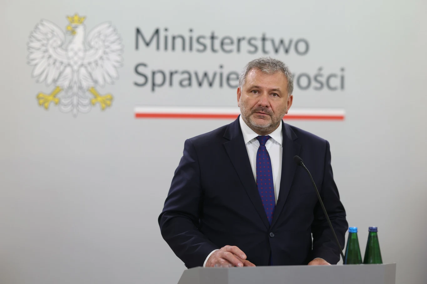 Waldemar Żurek zapowiedział ofensywę w sprawie TK i Sądu Najwyższego, która rozpocznie się jesienią Waldemar Żurek przemawia przy pulpicie z mikrofonem, w tle logo Ministerstwa Sprawiedliwości i godło Polski.